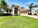 One story house with tan exterior, attached garage and well manicured lawn at 29405 Cochiti Lake Dr, San Antonio, FL 33576