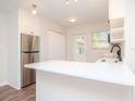 Modern white kitchen with stainless steel appliances and quartz countertops at 4415 W Wisconsin Ave, Tampa, FL 33616