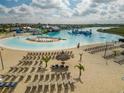 Beach entry pool with many lounge chairs and a tiki bar at 17039 Oval Rum Dr, Wimauma, FL 33598