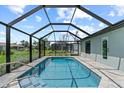 Enclosed rectangular pool with gray pavers and a screened enclosure at 7075 Brandywine Dr, Englewood, FL 34224