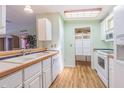 White kitchen with wood countertops and appliances at 37607 Neukom Ave, Zephyrhills, FL 33541