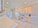 Eat-in kitchen features ample counter space, white appliances, and a tile backsplash at 1007 Emerald Dunes Dr, Sun City Center, FL 33573