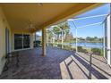 Spacious screened-in lanai with brick flooring and scenic lake views, perfect for outdoor entertaining at 1007 Emerald Dunes Dr, Sun City Center, FL 33573