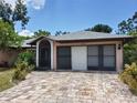House exterior with brick driveway and two-car garage at 22491 Delhi Ave, Port Charlotte, FL 33952