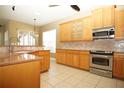 Kitchen features light wood cabinets, granite countertops and stainless steel appliances at 4922 Sandy Brook Cir, Wimauma, FL 33598