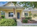 Front view of a yellow house with a blue door and well-manicured landscaping at 6619 Current Dr, Apollo Beach, FL 33572