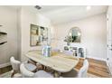 Well-lit dining room includes a rustic wood table, soft neutral chairs, and refined decor, offering an inviting space at 7201 S De Soto St, Tampa, FL 33616