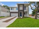 Modern two-story house with a dark-brown accent wall and light-grey siding at 7201 S De Soto St, Tampa, FL 33616