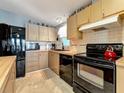 Bright kitchen with black appliances and light wood cabinets at 199 S Port Royal Ln, Apollo Beach, FL 33572