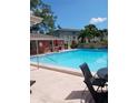 Community swimming pool with tables and chairs at 4507 9Th W St # E8, Bradenton, FL 34207