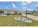Landscaped yard with driveway leading to a single-story home at 1607 Cloister Dr, Sun City Center, FL 33573