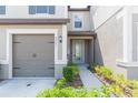 Townhome with a two-car garage and a private walkway entrance at 8065 Rolling Shell Trl, Wesley Chapel, FL 33545
