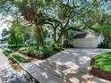 Two-story white brick home with mature trees and a large driveway at 2902 W Bayshore Ct, Tampa, FL 33611