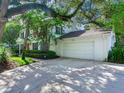 Two-story white brick home with mature trees and a large driveway at 2902 W Bayshore Ct, Tampa, FL 33611