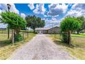 Gravel driveway leading to a stone ranch home at 31226 Saint Joe Rd, Dade City, FL 33525
