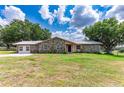 Stone ranch house with metal roof and large yard at 31226 Saint Joe Rd, Dade City, FL 33525