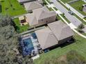 Aerial view of a well-maintained backyard pool, manicured lawn, and cozy gazebo, perfect for outdoor entertaining at 12607 Flatwood Creek Dr, Gibsonton, FL 33534