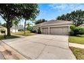 One-story home with three-car garage and driveway at 12902 Cattail Shore Ln, Riverview, FL 33579