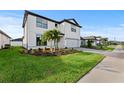 Two-story home with gray driveway and landscaping, side yard view at 2148 Laurifolia Ct, North Port, FL 34289