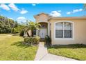 House exterior showcasing a light-colored facade, entryway, and walkway at 30315 Lettingwell Cir, Wesley Chapel, FL 33543