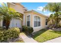 Front entrance of a single story house featuring a double door and lush landscaping at 30315 Lettingwell Cir, Wesley Chapel, FL 33543