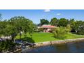 Single story home on waterfront property with a large green lawn at 2111 W Ivy St, Tampa, FL 33607