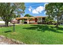 Single-Gathering home with a red and yellow exterior and a green lawn at 2111 W Ivy St, Tampa, FL 33607