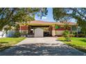House exterior featuring a carport, shed, and a hot tub in the backyard at 2111 W Ivy St, Tampa, FL 33607