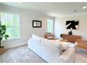 Bright living room with a light gray sofa, two armchairs, and large windows at 17476 Quentin Ave, Port Charlotte, FL 33954