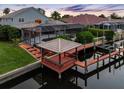 Backyard canal view with a gazebo, boat dock, screened in pool, and lush landscaping at 5510 E Longboat Blvd, Tampa, FL 33615