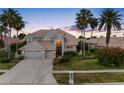 Charming two-story home featuring a three-car garage, well-manicured lawn, and mature palm trees at 5510 E Longboat Blvd, Tampa, FL 33615
