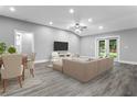 Bright, open living and dining area with gray walls, wood-look flooring and plenty of natural light at 11734 Orange Ct, Dade City, FL 33525