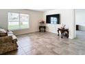 Bright living room with tile floors, sofa, and large TV at 13292 Golden Lime Ave, Spring Hill, FL 34609