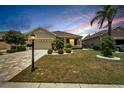 House exterior at dusk with landscaping and paved driveway at 1013 Emerald Dunes Dr, Sun City Center, FL 33573