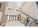 High-ceiling living room with modern staircase and chandelier at 6018 Kipps Colony E Dr, Gulfport, FL 33707