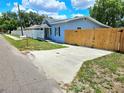 Cute blue house with a fenced yard and a long driveway at 1703 Mobile Ave, Tampa, FL 33610