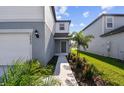 Front entry of two-story home with walkway, landscaping, and gray siding at 10623 Hidden Banks Gln, Parrish, FL 34219