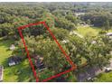 Vacant lot surrounded by mature trees and residential properties at 7207 Westinghouse Ave, Tampa, FL 33619