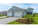 Two-car garage home with light blue exterior and landscaping at 12706 Palatka Dr, Venice, FL 34293