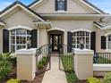 Elegant entryway with wrought iron gate, manicured landscaping, and stylish lighting at 33724 Americana Ave, Dade City, FL 33525