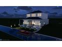 Contemporary two-story home with covered lanai and an expansive waterfront pool and dock at night at 5243 Wishing Arch Dr, Apollo Beach, FL 33572