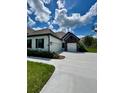 Spacious three-car garage with white doors and a concrete driveway at 13530 Oldenburg Dr, Hudson, FL 34667