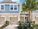 Inviting two-story home with blue siding, double garage, and lush landscaping at 11522 Cambium Crown Dr, Riverview, FL 33569