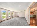 Bright, open living room with large windows, plush carpeting, and hardwood floors leading to other spaces at 2115 Seagull Dr, Clearwater, FL 33764