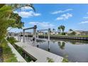 Waterfront property with a large boat lift on a private dock surrounded by lush trees and waterfront homes at 6542 Simone Shores Cir, Apollo Beach, FL 33572