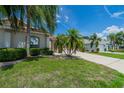 Single-story house with palm trees, lush lawn, and a two-car garage at 912 Oxford Park Dr, Sun City Center, FL 33573