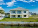 Two-story house with balcony, waterfront view, and grassy yard at 3431 Sheephead Dr, Hernando Beach, FL 34607