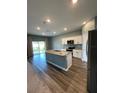 Open kitchen with granite counters, stainless appliances, large island, and sliding doors to the backyard at 462 Spotted Slipper Pl, Ruskin, FL 33570