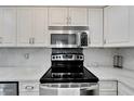 Modern kitchen with stainless steel appliances and white cabinets at 1028 Apollo Beach Blvd # 27, Apollo Beach, FL 33572