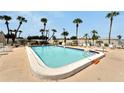 Community pool with lounge chairs and palm trees at 1028 Apollo Beach Blvd # 27, Apollo Beach, FL 33572